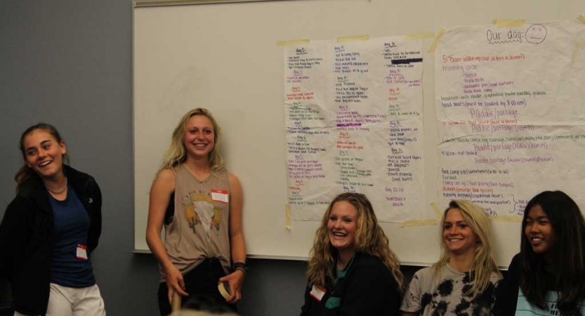 a group of young people stand beside a whiteboard at the family seminar of an outward bound intercept course